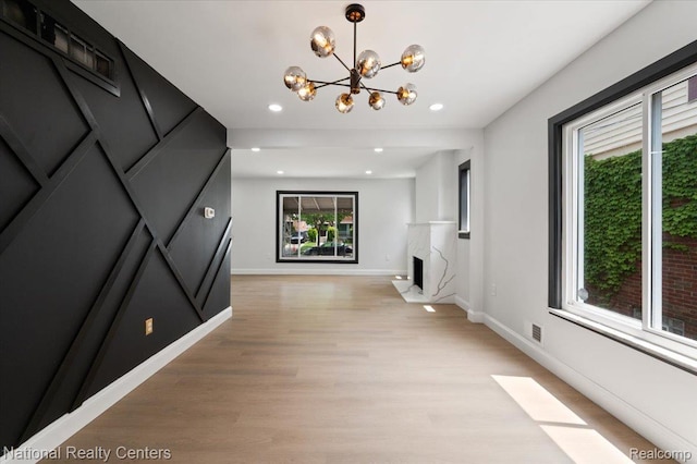 17169 Griggs St, Detroit, MI 48221 - unfurnished living room with a chandelier, light wood-type flooring, baseboards, recessed lighting, and a premium fireplace