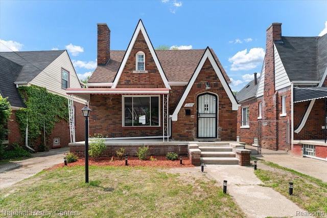 17169 Griggs St, Detroit, MI 48221 - tudor-style house with brick siding, a chimney, and a porch