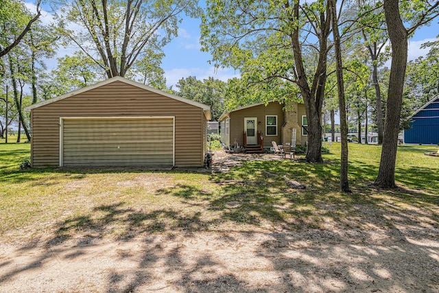 32205 James St, Colon, MI 49040 - view of front of house featuring entry steps, an outdoor structure, a garage, and a front yard