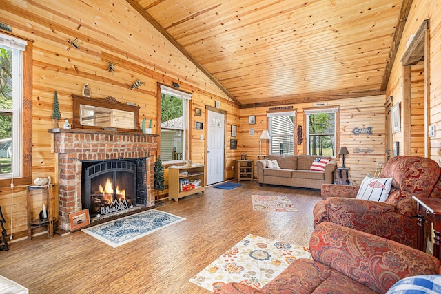 32205 James St, Colon, MI 49040 - living room featuring lofted ceiling, wooden walls, wood finished floors, a fireplace, and wood ceiling