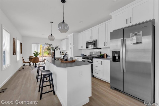 2819 16th St, Detroit, MI 48216 - kitchen with stainless steel appliances, light wood-style floors, and a kitchen island with sink