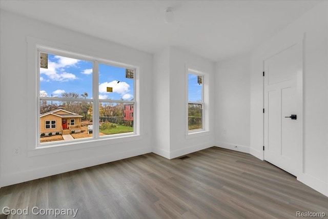 2827 16th St, Detroit, MI 48216 - unfurnished bedroom featuring wood finished floors and multiple windows