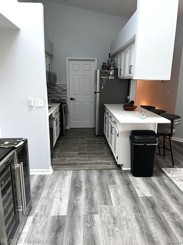 1565 Harbour Blvd Unit 182, Trenton, MI 48183 - kitchen featuring wood finished floors, wine cooler, white cabinets, light countertops, and black microwave