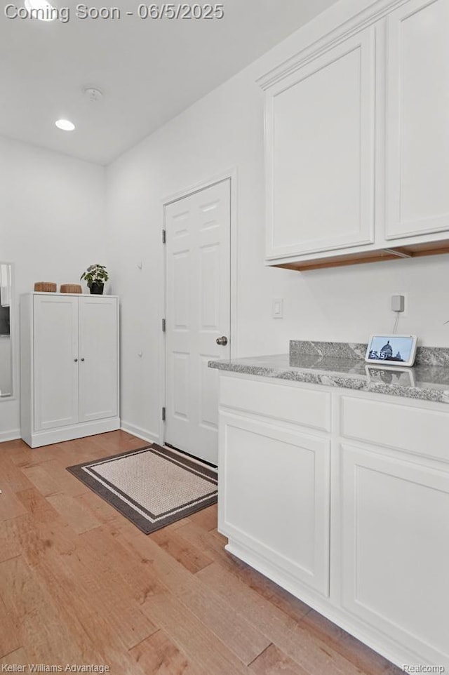 861 N Mill St, South Lyon, MI 48178 - kitchen with light wood finished floors, white cabinetry, light stone counters, and recessed lighting
