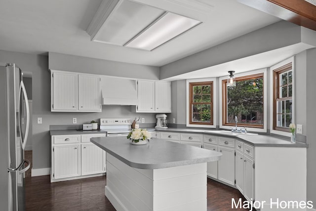 7125 Brooklyn Ave SE, Grand Rapids, MI 49508 - kitchen with custom exhaust hood, freestanding refrigerator, a sink, dark wood-type flooring, and white cabinetry
