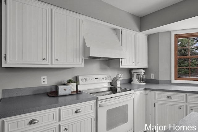 7125 Brooklyn Ave SE, Grand Rapids, MI 49508 - kitchen featuring white range with electric cooktop, white cabinets, custom range hood, and dark countertops