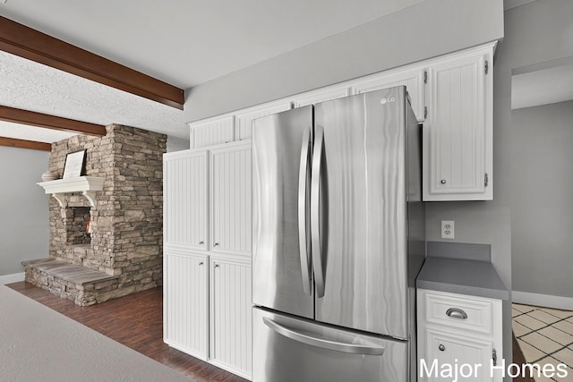 7125 Brooklyn Ave SE, Grand Rapids, MI 49508 - kitchen featuring freestanding refrigerator, beamed ceiling, white cabinetry, dark countertops, and baseboards