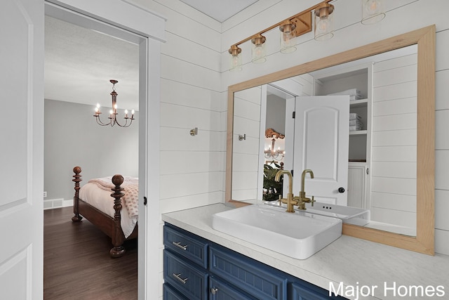 7125 Brooklyn Ave SE, Grand Rapids, MI 49508 - bathroom with vanity, a chandelier, and wood finished floors