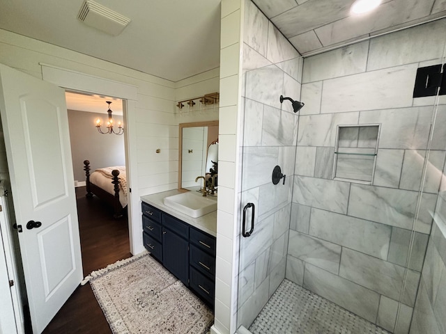 7125 Brooklyn Ave SE, Grand Rapids, MI 49508 - bathroom with connected bathroom, a stall shower, wood finished floors, vanity, and a chandelier