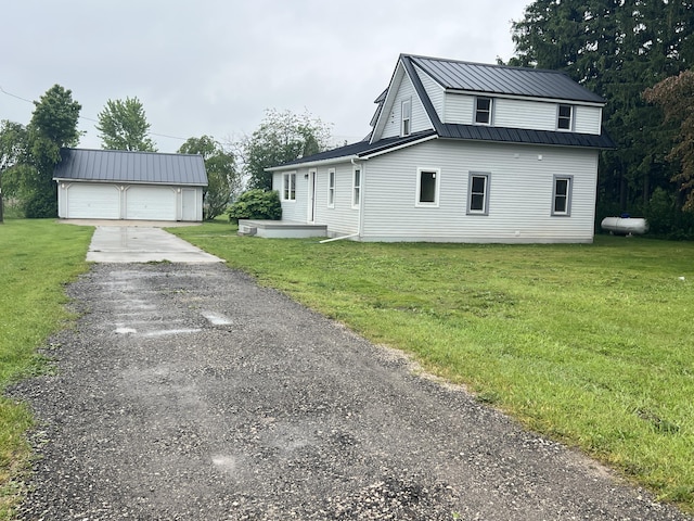 855 E Hansen Rd, Scottville, MI 49454 - view of home's exterior with a garage, an outdoor structure, and a lawn