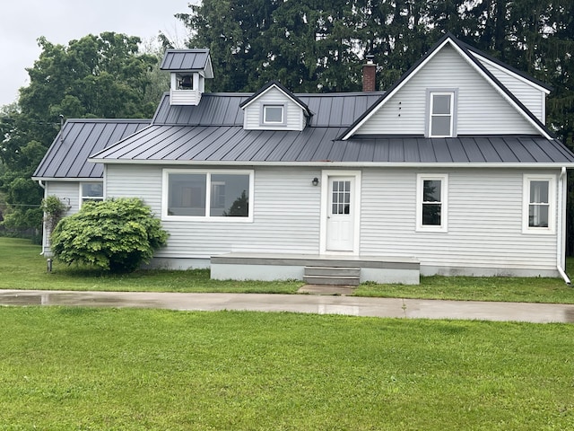 855 E Hansen Rd, Scottville, MI 49454 - view of front of property with a standing seam roof, a front yard, metal roof, and a chimney