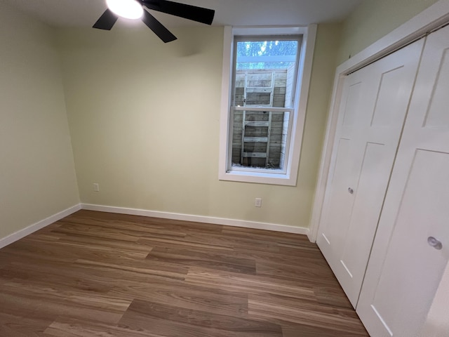 855 E Hansen Rd, Scottville, MI 49454 - unfurnished bedroom featuring dark wood-style flooring, baseboards, ceiling fan, and a closet