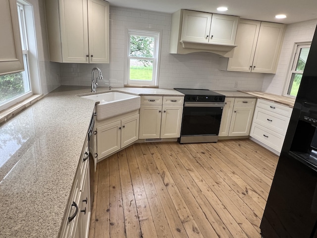 855 E Hansen Rd, Scottville, MI 49454 - kitchen with black appliances, a sink, light wood-style flooring, and tasteful backsplash