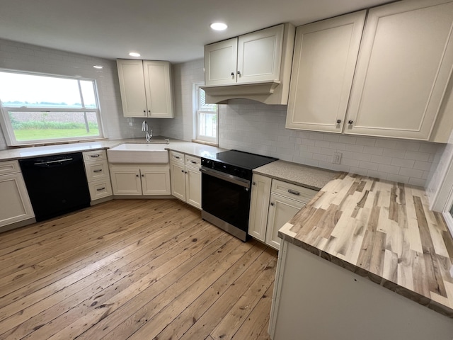 855 E Hansen Rd, Scottville, MI 49454 - kitchen featuring black appliances, a sink, butcher block counters, light wood-style flooring, and custom exhaust hood
