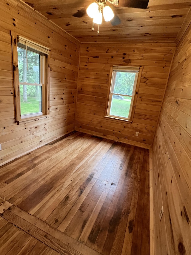 855 E Hansen Rd, Scottville, MI 49454 - unfurnished room featuring wooden walls, a ceiling fan, hardwood / wood-style flooring, and wood ceiling