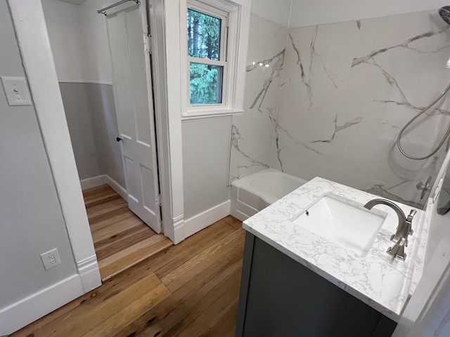 855 E Hansen Rd, Scottville, MI 49454 - bathroom with vanity, baseboards, wood finished floors, and bathtub / shower combination
