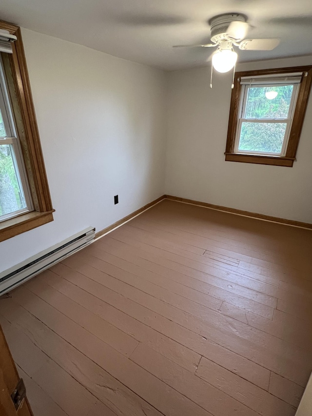 855 E Hansen Rd, Scottville, MI 49454 - empty room with ceiling fan, baseboard heating, baseboards, and wood finished floors