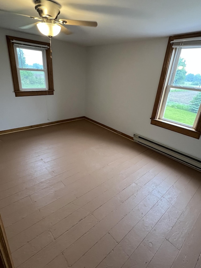 855 E Hansen Rd, Scottville, MI 49454 - spare room with a ceiling fan, hardwood / wood-style floors, a baseboard radiator, and baseboards