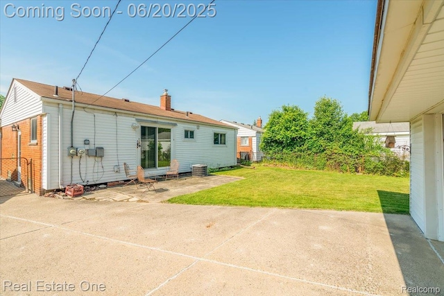 32622 Parkwood St, Westland, MI 48186 - rear view of house with a patio area, a lawn, and a chimney