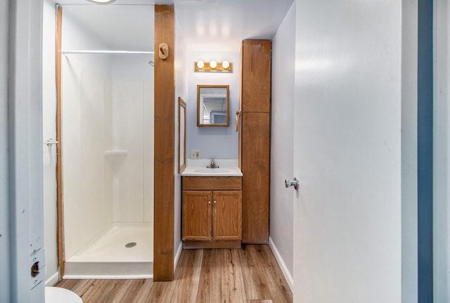707 Maple St, Big Rapids, MI 49307 - bathroom with wood finished floors, vanity, a shower stall, baseboards, and toilet