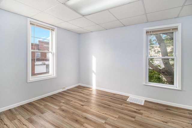 707 Maple St, Big Rapids, MI 49307 - unfurnished room with a drop ceiling, light wood-style floors, and baseboards