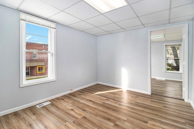 707 Maple St, Big Rapids, MI 49307 - unfurnished room featuring a paneled ceiling, light wood-style flooring, and baseboards