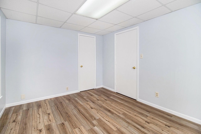 707 Maple St, Big Rapids, MI 49307 - empty room featuring wood finished floors, a paneled ceiling, and baseboards