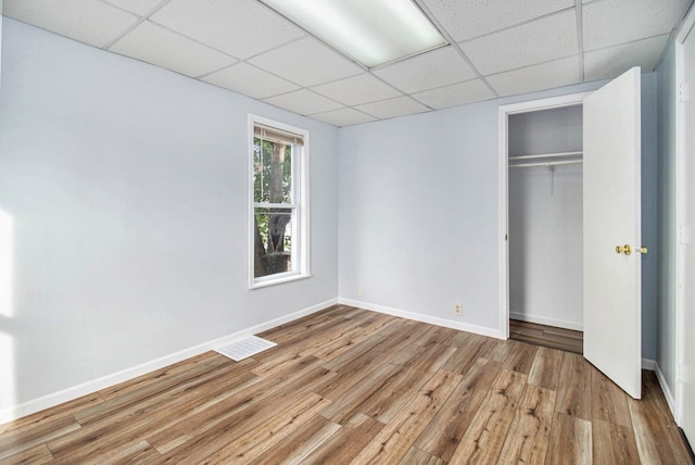 707 Maple St, Big Rapids, MI 49307 - unfurnished bedroom featuring a paneled ceiling, wood finished floors, a closet, and baseboards