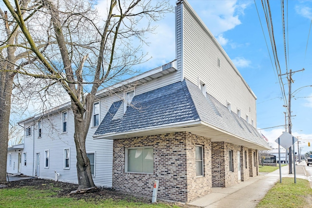 707 Maple St, Big Rapids, MI 49307 - view of side of home with brick siding and a chimney