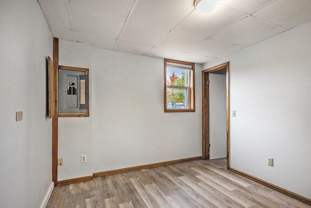 707 Maple St, Big Rapids, MI 49307 - basement with electric panel, light wood-type flooring, a paneled ceiling, and baseboards