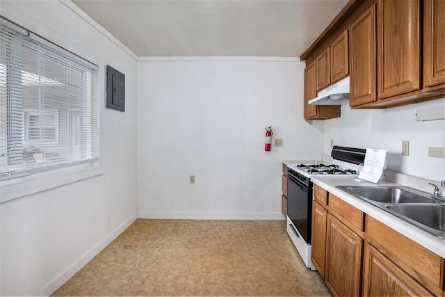 707 Maple St, Big Rapids, MI 49307 - kitchen with gas range, under cabinet range hood, brown cabinetry, electric panel, and a sink