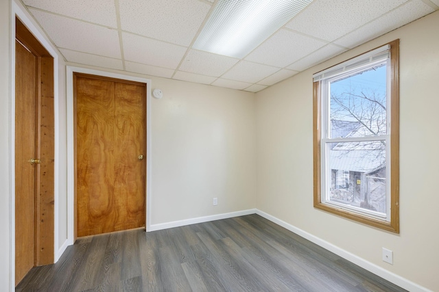 707 Maple St, Big Rapids, MI 49307 - unfurnished bedroom featuring a paneled ceiling, dark wood-style floors, and baseboards