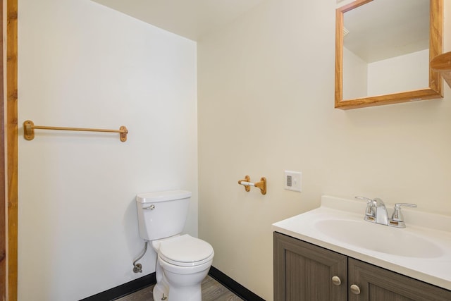 707 Maple St, Big Rapids, MI 49307 - half bath with toilet, baseboards, vanity, and wood finished floors