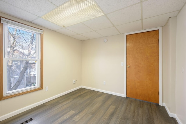 707 Maple St, Big Rapids, MI 49307 - empty room with a paneled ceiling, dark wood-type flooring, and baseboards
