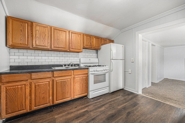 707 Maple St, Big Rapids, MI 49307 - kitchen with white appliances, dark countertops, brown cabinetry, and vaulted ceiling