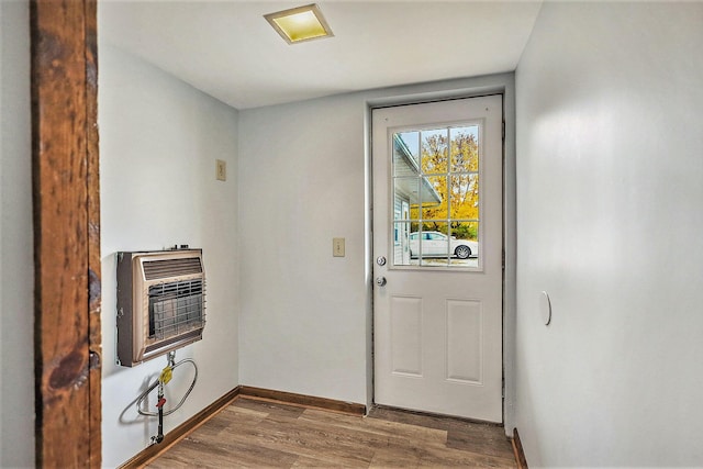 707 Maple St, Big Rapids, MI 49307 - doorway to outside featuring heating unit, wood finished floors, and baseboards