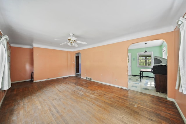 311 Rosehill Rd, Jackson, MI 49202 - empty room with arched walkways, hardwood / wood-style floors, a ceiling fan, and baseboards