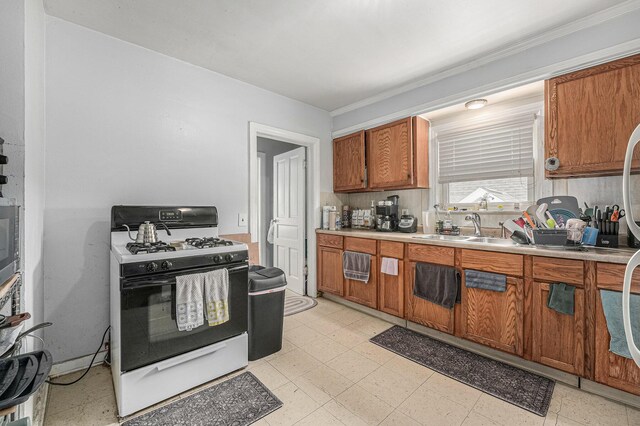 510 Woodlawn St SE, Grand Rapids, MI 49507 - kitchen featuring gas stove, brown cabinetry, light countertops, a sink, and ornamental molding