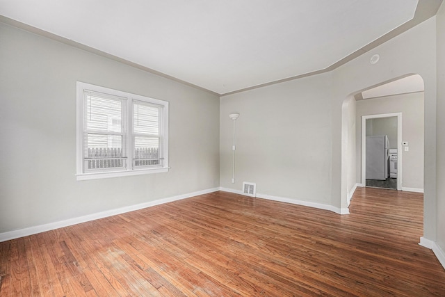 510 Woodlawn St SE, Grand Rapids, MI 49507 - unfurnished room with arched walkways, hardwood / wood-style floors, and baseboards