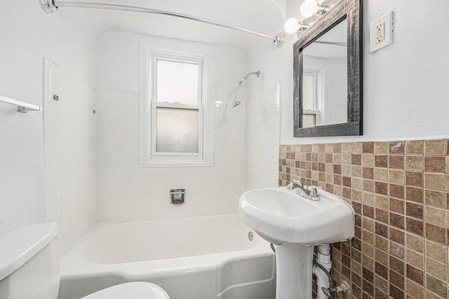510 Woodlawn St SE, Grand Rapids, MI 49507 - full bath featuring toilet, tile walls, washtub / shower combination, and a wainscoted wall