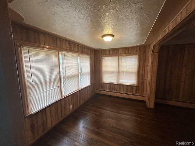 18821 Dalby, Redford, MI 48240 - spare room with baseboard heating, wood walls, dark wood-type flooring, and a textured ceiling