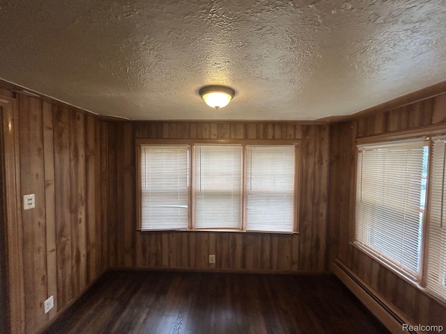 18821 Dalby, Redford, MI 48240 - spare room with dark wood-type flooring, wooden walls, a baseboard heating unit, and a textured ceiling
