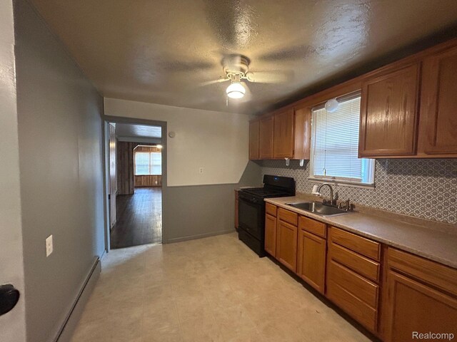 18821 Dalby, Redford, MI 48240 - kitchen with black gas range, a sink, tasteful backsplash, and brown cabinetry