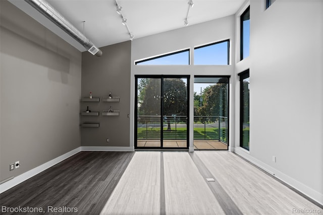 1711 Livernois St Unit 7, Ferndale, MI 48220 - unfurnished room featuring track lighting, wood finished floors, a high ceiling, and baseboards
