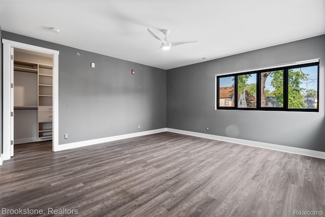 1711 Livernois St Unit 7, Ferndale, MI 48220 - unfurnished bedroom featuring dark wood finished floors, a spacious closet, baseboards, and ceiling fan