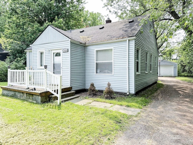 19549 Melrose Ave, Southfield, MI 48075 - view of front facade with a chimney, a shingled roof, a front lawn, an outbuilding, and a garage