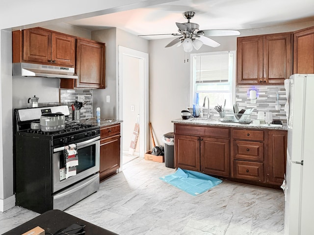 19549 Melrose Ave, Southfield, MI 48075 - kitchen featuring stainless steel gas range oven, under cabinet range hood, a sink, freestanding refrigerator, and brown cabinets