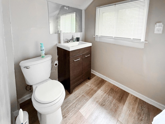 19549 Melrose Ave, Southfield, MI 48075 - bathroom with toilet, vanity, wood finished floors, baseboards, and vaulted ceiling