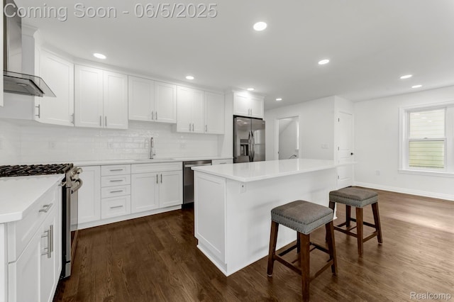 1285 Ruffner Ave, Birmingham, MI 48009 - kitchen featuring appliances with stainless steel finishes, wall chimney exhaust hood, a sink, dark wood-style floors, and recessed lighting
