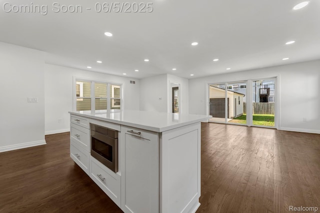 1285 Ruffner Ave, Birmingham, MI 48009 - kitchen featuring stainless steel microwave, baseboards, white cabinetry, dark wood finished floors, and light countertops